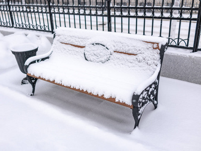冬天公园里的一张空板凳，里面装满了新鲜的白雪。 复制背景