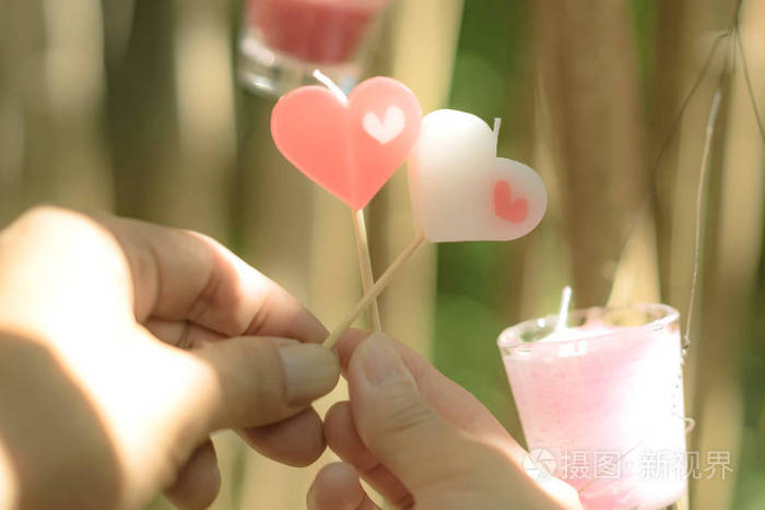情人节的浪漫情侣幸福快乐的夫妻在下午给对方心灵蜡烛的爱情概念