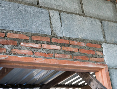 在安装未完工房屋的木门之前，应在木架上安装砖墙。