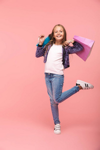 活泼开朗的小女孩背着购物袋，与粉色背景隔绝