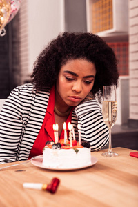 无表情的不幸的女人有一个悲伤的生日庆祝活动