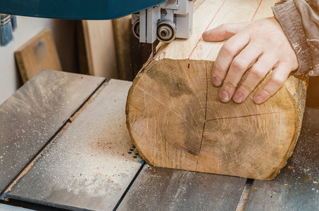 手连接器在带锯上切割一根日志。 木工木制品