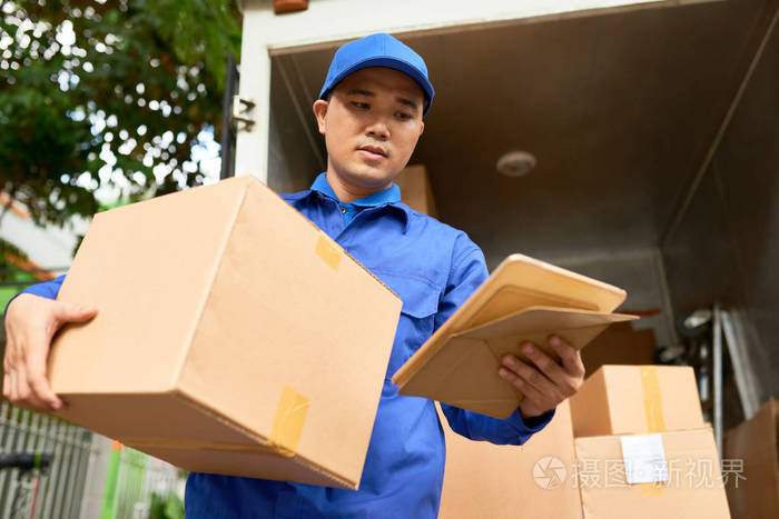 寄包裹前快递员在平板电脑上阅读地址