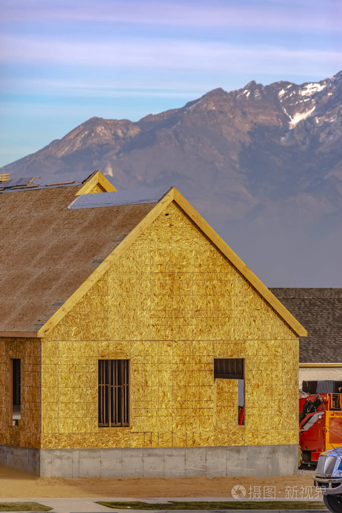在建的房子对瓦萨奇山. 家在建设中,有山野和多云的蓝天背景.