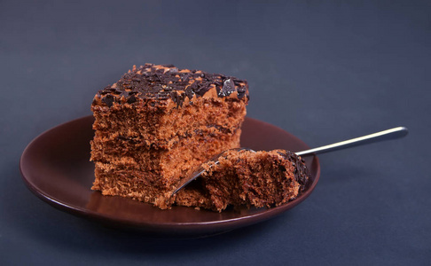 黑桌上盘子里美味的巧克力蛋糕