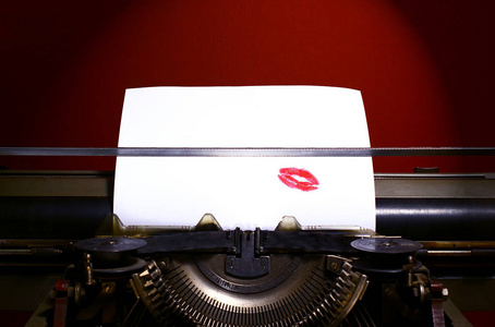 老式手动打字机。 红色口红印在纸上。