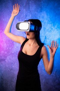 想知道年轻的女人在虚拟现实眼镜在霓虹灯色的背景。戴着 vr 装置的惊心动魄的女孩。女性与 vr 耳机的特写镜头