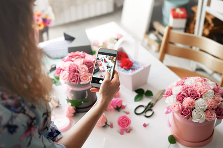 花店 一个女孩花店收集一个篮子里的花束, 并在智能手机上为社交网络拍照
