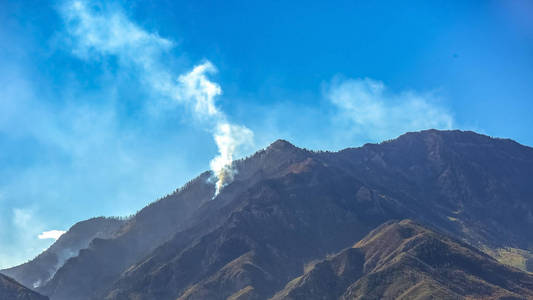 犹他州包兹山在蔚蓝的天空下的大火