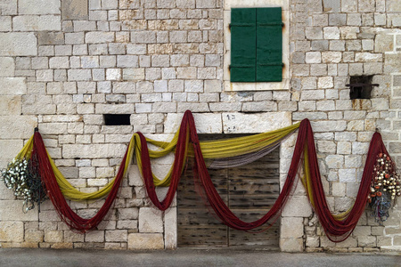 s net on the old stone facade near wooden door in Povlja, Brac I