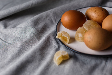在白色碟子上是煮鸡蛋和果酱在亚麻桌布上，有复制空间。