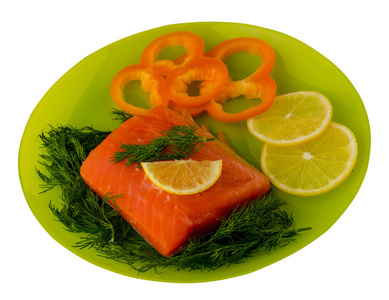 红鱼鳟鱼片在盘子上。 在白色背景上分离的鱼鳟鱼。 鳟鱼加柠檬和胡椒