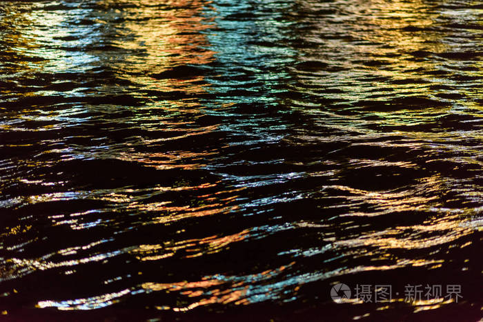 夜晚城市的灯光反射在水中水面上的涟漪晚上的时间夜晚的海景水的质地