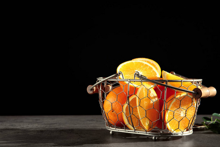 新鲜多汁的橘子放在灰色桌子上的篮子里。 文本空间
