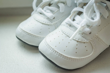 白色背景上的一双白色运动鞋。婴儿运动鞋, 跑鞋。儿童鞋。莫卡辛婴儿踩皮革第一步购物。婴儿鞋隔离。童鞋或儿童鞋
