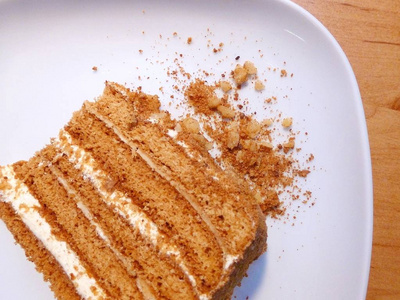 传统蜂蜜蛋糕切片的顶部视图，白色盘子上有碎屑。