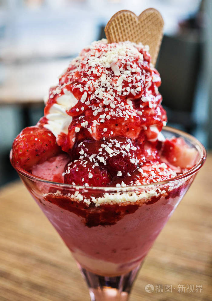 冰淇淋甜点草莓和鲜奶油在玻璃杯中供应