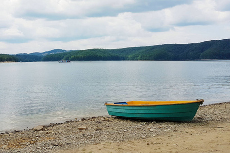 毛杂杂泊船停泊在湖边的沙质海岸. 靠近水的人的度假和娱乐.