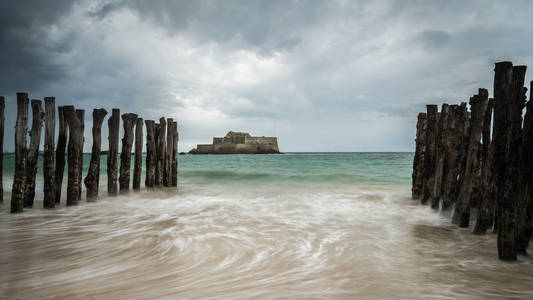 在夏季暴风雨的阴天，圣马洛法国布雷塔涅涨潮期间的海滩和国家堡垒