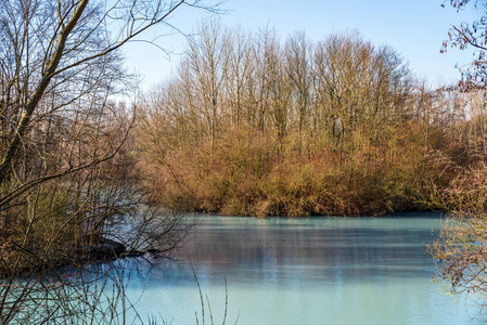 在阳光明媚的一天，德国博丘姆冬季的绿松石色池塘