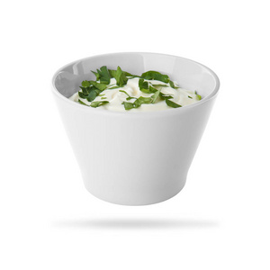 陶瓷碗，有美味的酸奶油和白色背景的草药