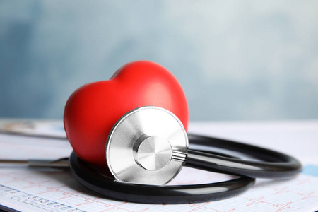 听诊器红色心脏和心脏图在桌子上。 心脏学概念