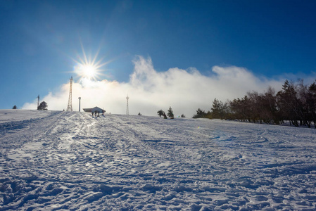 白雪覆盖了群山。 雪中的松树。 蓝天。 厚厚的白云。 海拔高度。 山叫艾皮特里。 克里米亚山。 金属无线电塔。 旅游业。 在克