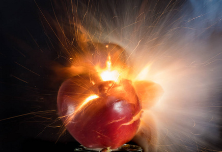 一个苹果和柠檬在黑色背景上爆炸，爆炸