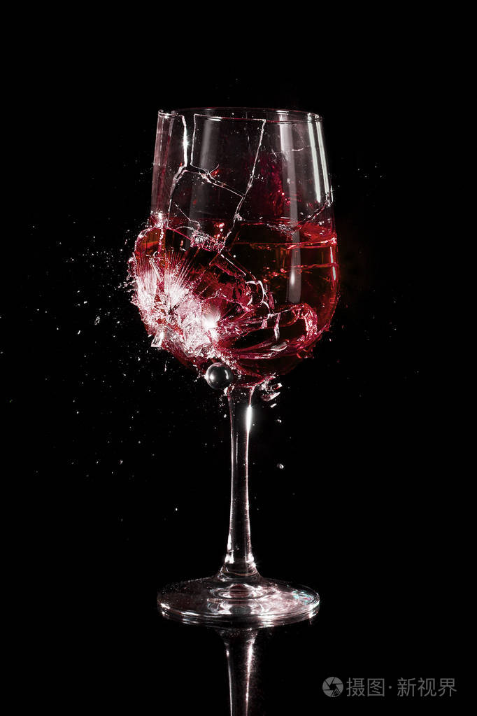 一杯葡萄酒在黑色背景下粉碎