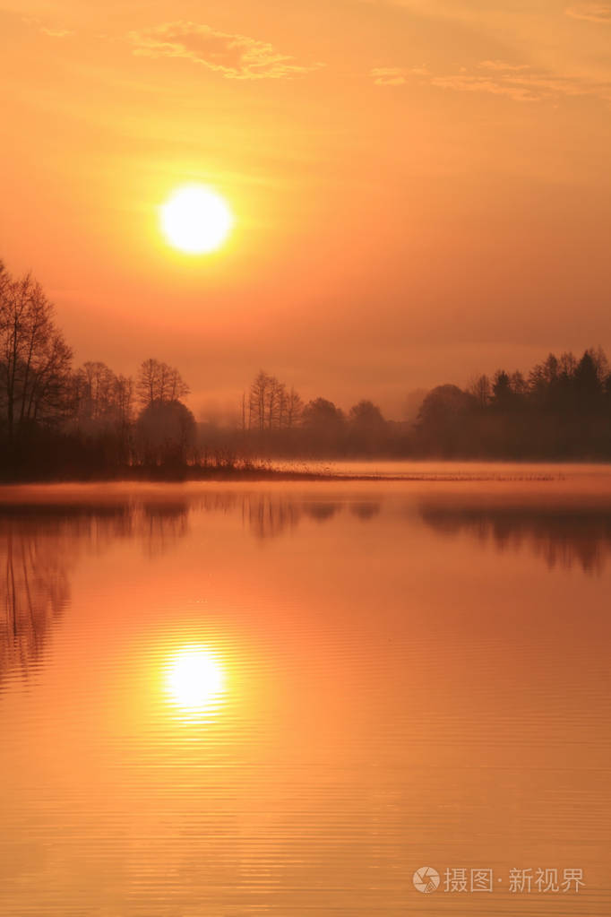 不寻常的日出在湖面上