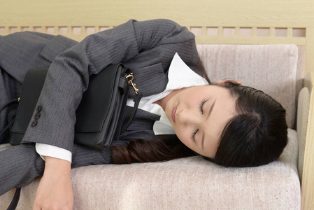 疲惫的商务女性睡在沙发上