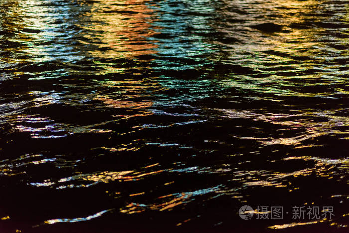 夜晚城市的灯光反射在水中水面上的涟漪晚上的时间夜晚的海景水的质地