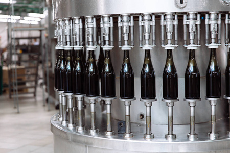 香槟或葡萄酒厂自动输送线上的玻璃瓶.瓶装酒精饮料厂照片