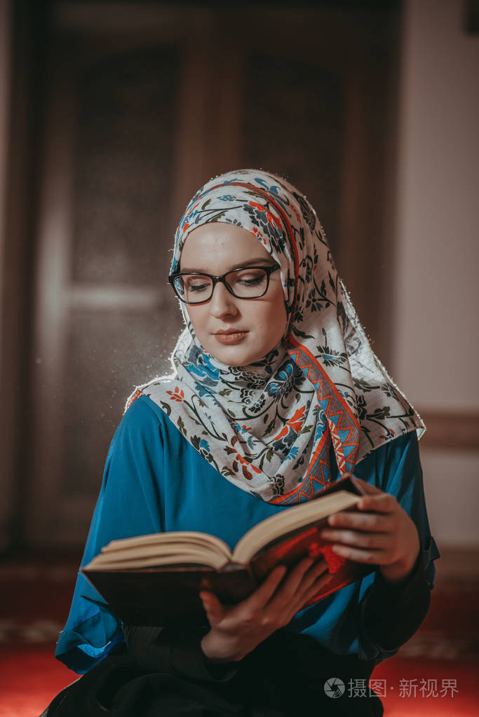 穆斯林女孩祈祷和重新阅读古兰经