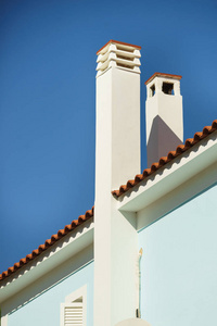 极简主义的高烟囱在屋顶上的蓝天上。 家庭详细对象概念。