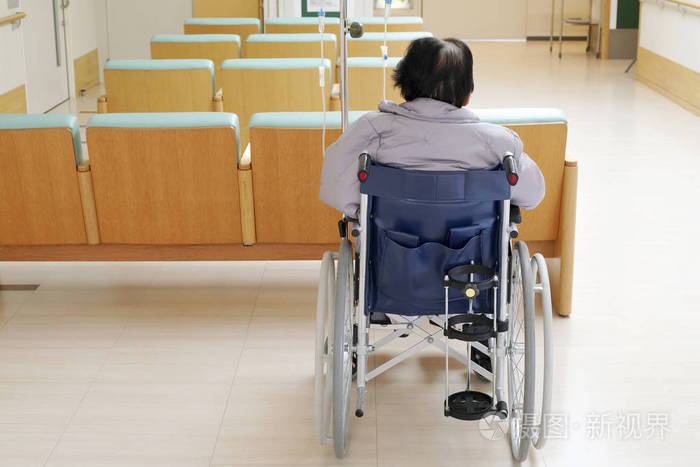坐在医院轮椅上的老年妇女的后景