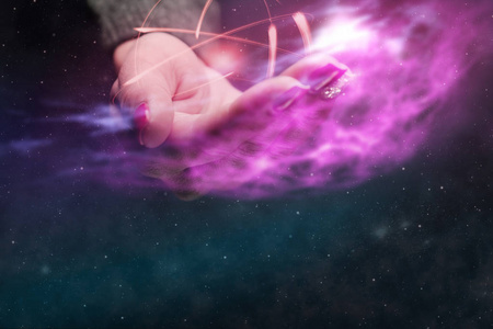 人类的手在手掌上握着原子。 无限空间中的星云尘埃。 混合媒体。