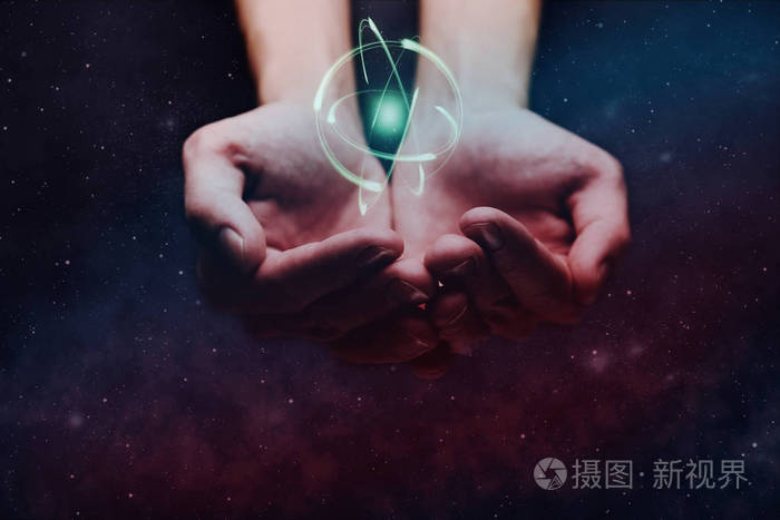 人类的手在手掌上握着原子无限空间中的星云尘埃混合媒体
