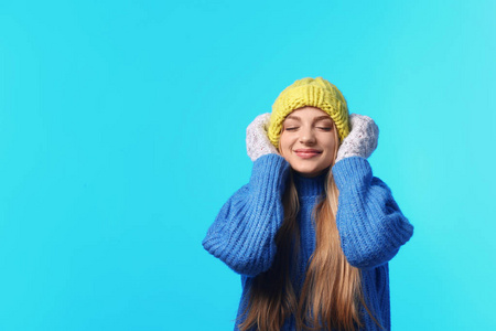 情感年轻女子的肖像，在时尚的帽子毛衣和手套的颜色背景空间为文本。 冬季气氛