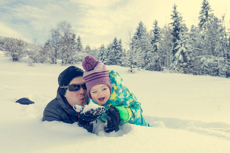 父亲和女儿在新鲜的雪中玩耍