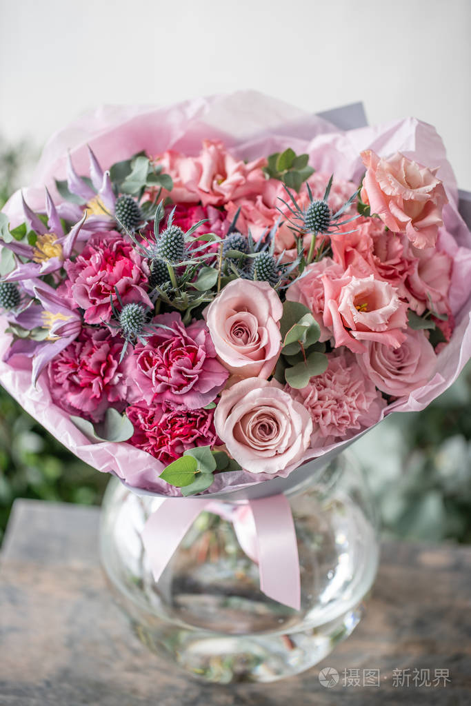 在木桌上的花瓶里, 美丽的新鲜切花花束.花店的花商的作品.