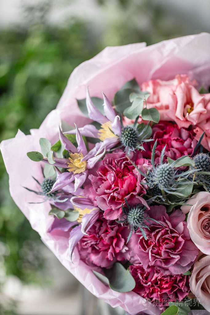 在木桌上的花瓶里, 美丽的新鲜切花花束.花店的花商的作品.