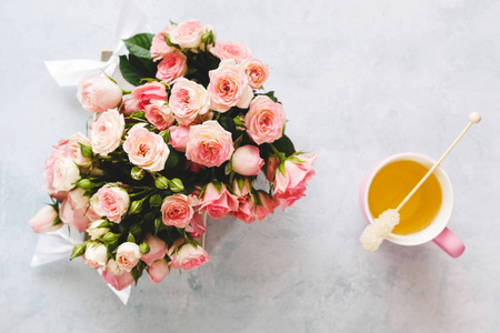 礼品盒，玫瑰花和一杯茶在纹理表面。 顶部视图空白空间
