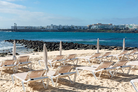 科斯塔特吉斯市海滩上一排排空甲板椅。 兰萨罗特岛西班牙。