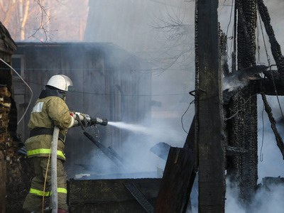 消防员灭火。烟雾中的消防员用软管里的水浇在燃烧的大楼里。