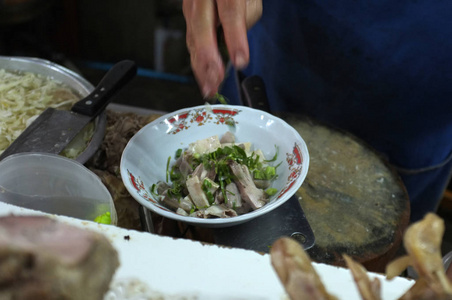 厨师烹饪面条与猪肉和猪肉内脏在当地餐厅泰国街头食品在萨肯纳洪泰国。