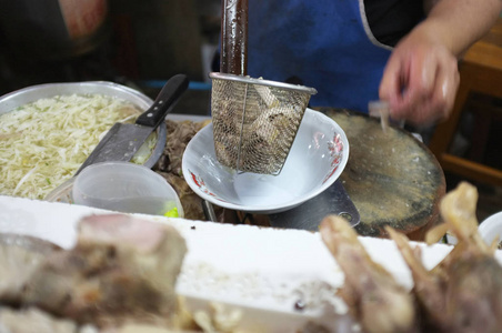 厨师烹饪面条与猪肉和猪肉内脏在当地餐厅泰国街头食品在萨肯纳洪泰国。