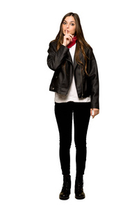 穿着皮夹克的年轻女子的完整镜头显示出一种沉默的姿态，手指放在孤立的白色背景上