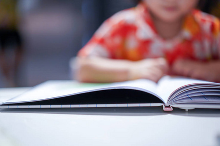  focus at the book on the white, blur kids at the background. Pr