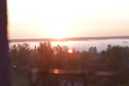 从窗口查看。黎明背景下的雾